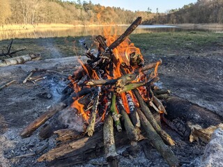 duże ognisko na polanie harcerskiej nad jeziorem jesienią