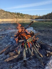 duże ognisko na polanie harcerskiej nad jeziorem jesienią