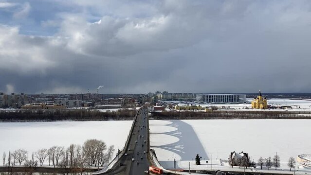 View from Fedorovsky Embankment in Nizhny at the Kanavinsky Bridge that casts a shadow on the frozen Oka river, the Lower City with the Stadium, the Alexander Nevsky Cathedral and multi-storey houses