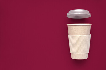 Paper cup with cap on viva magenta background with space for text