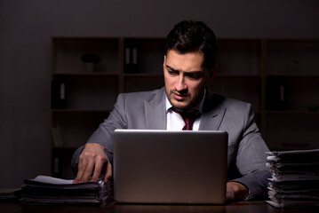 Young male employee working late in the office