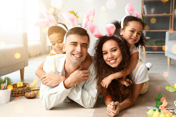 Happy interracial family in Easter bunny ears at home