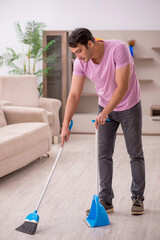 Young male contractor cleaning the house