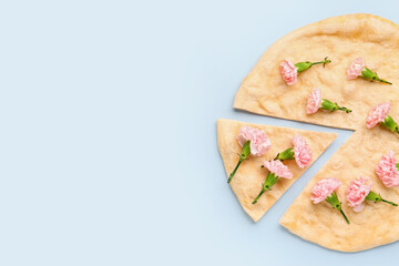 Pizza with beautiful carnation flowers on light background