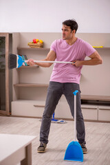 Young male contractor cleaning the house