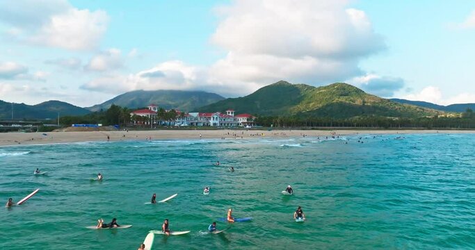 People surf freely and leisurely on waves,enjoying a happy lifestyle in Riyue Bay, Wanning City, Hainan, China