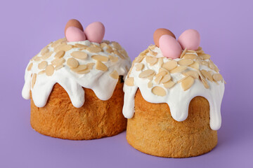 Easter cakes with painted eggs on purple background