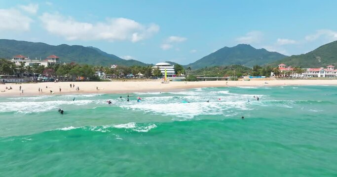 People surf on the beach for vacation and enjoy leisure time in Riyue Bay, Wanning City, Hainan, China
