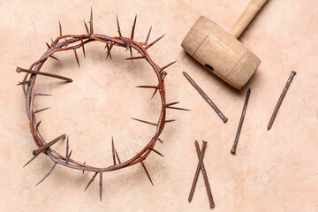 Crown of thorns with nails and mallet on beige background. Good Friday concept