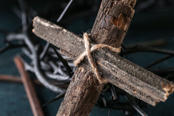 Wooden cross, crown of thorns and nails on dark background, closeup. Good Friday concept