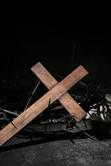 Wooden cross with crown of thorns on dark background. Good Friday concept