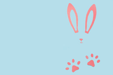 Composition with paper bunny ears, nose and paws on color background