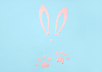 Composition with paper bunny ears, nose and paws on color background