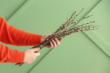 Obraz premium Woman holding willow branches on green background
