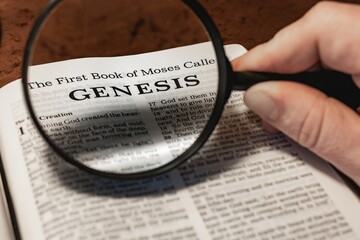 title page book of Genesis close up using magnifying glass in the bible or Torah for faith,...