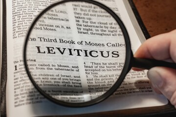 title page book of Leviticus close up using magnifying glass in the bible or Torah for faith,...