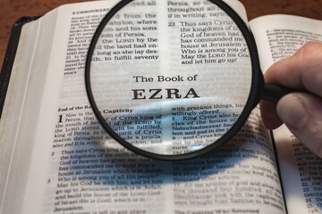 title page book of ezra close up using magnifying glass in the bible or Torah for faith, christian,...