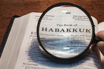 title page book of Habakkuk close up using magnifying glass in the bible or Torah for faith,...