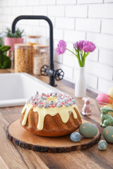 Easter cake with painted eggs, bunnies and tulip flowers on kitchen counter