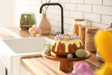 Dessert stand with Easter cake, painted eggs and bunny on kitchen counter