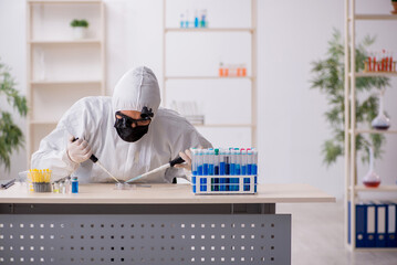 Young male chemist working at the lab during pandemic