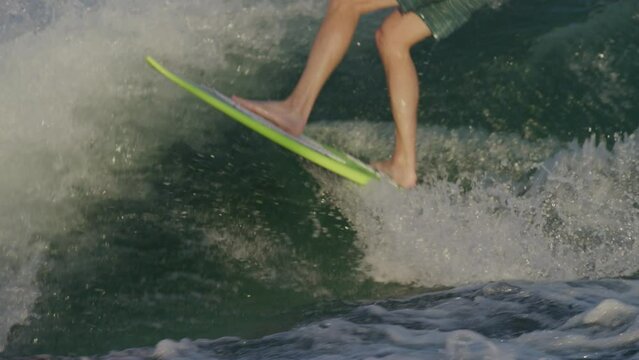 Slow motion close up of mans legs wake surfing behind boat in Lake Travis in Texas