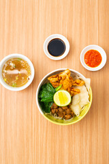 An bowl of chicken noodles served with potstickers