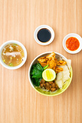 An bowl of chicken noodles served with potstickers