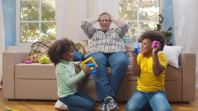Stressed caucasian nanny feeling migraine tired of too active kids. Realtime