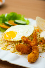 A Plate of seafood fried rice served with a side of shrimp fritters