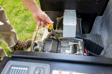 Man checking engine oil in generator, measuring oil level. Maintenance Mechanic Inspecting the...