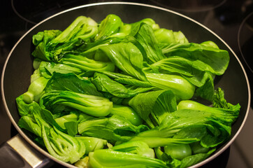 Bok choy stir fry on pan. Stir fried vegetables in a chinese wok. Stalks of baby bok choy cooking on the pan