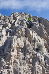 Woman Scrambling Down Limestone Cliff On Muddy Peak