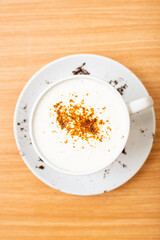A Glass of cappucino coffee, sprinkled with coffee powder on top of the foam