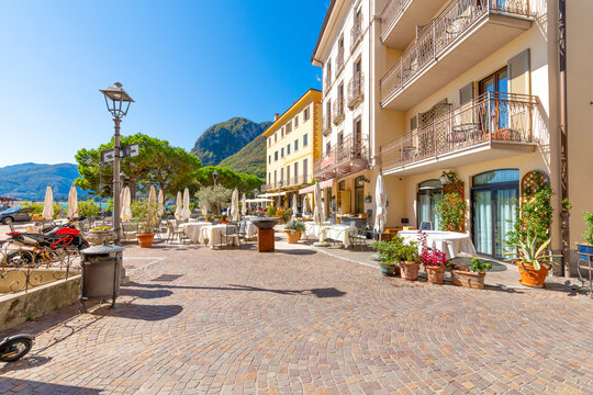 A lakefront outdoor sidewalk cafe in the colorful village of Menaggio, Italy, on the shores of Lake Como.