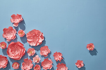Many pink flowers decorated on minimalist blue background for spring concepts. paper cut and craft...