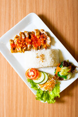 A Chicken Cutlet dish served weith rice and a side of salad, topped with rica rica chili