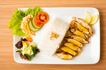 A Lemon Chicken Cutlet Dish, Servied with Rice and a side of salad