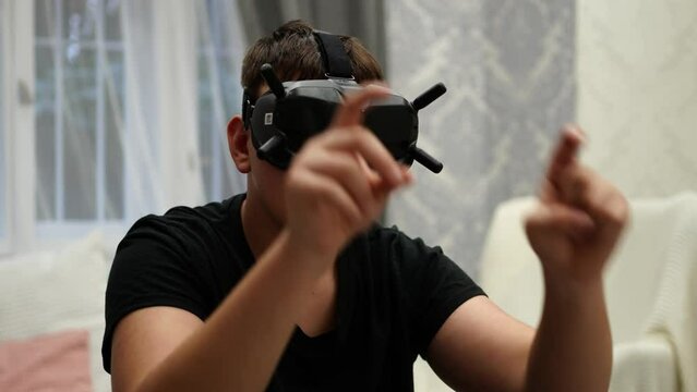 Young Man WIth Goggles VR Eyewear in Virtual Reality Tapping With Hands on Invisible Screen