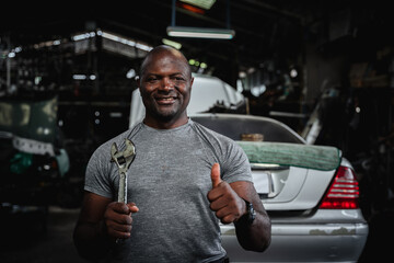 Portrait of  Car mechanic repairs and inspects the car's suspension in detail in the garage. Car...
