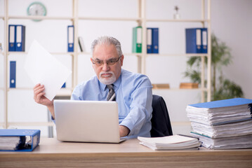 Old male employee working in the office
