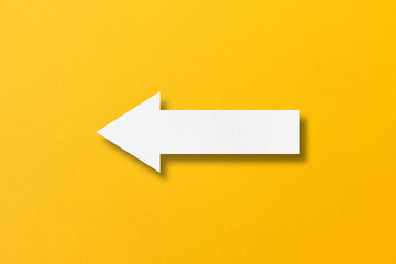 white paper arrow isolated on yellow paper background