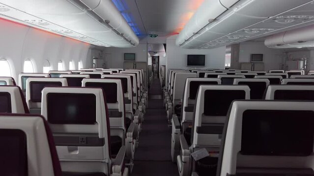 Luxury plane empty passenger seats interior.Salon wide view of the interior from passenger moving on aisle, slow motion