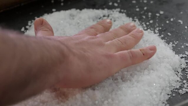 preparing a bed of salt for cooking on the grill