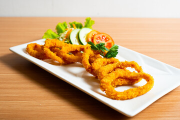 Deep fried onion rings served with tartar sauce and chili sauce