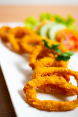Deep fried onion rings served with tartar sauce and chili sauce