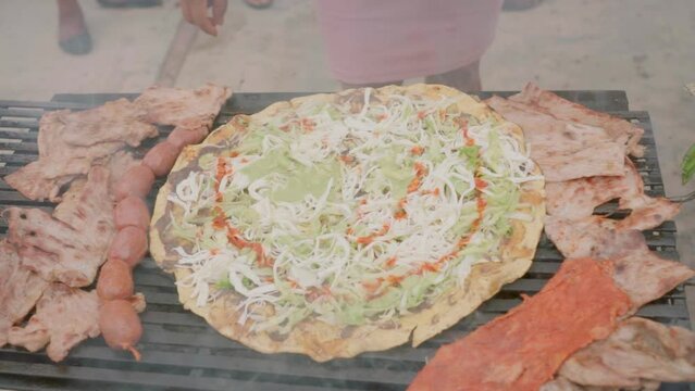 Preparing traditional Food Tlayuda with traditional Oaxaca cheese Quesillo