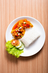 A Plate of spicy chicken deep fried chicken served with a plate of rice