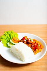 A Plate of spicy chicken deep fried chicken served with a plate of rice