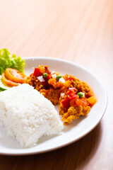 A Plate of spicy chicken deep fried chicken served with a plate of rice